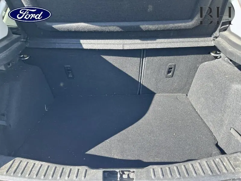 Vue du coffre ouvert de la Ford Focus blanc Glacier, montrant un espace de chargement propre et spacieux.