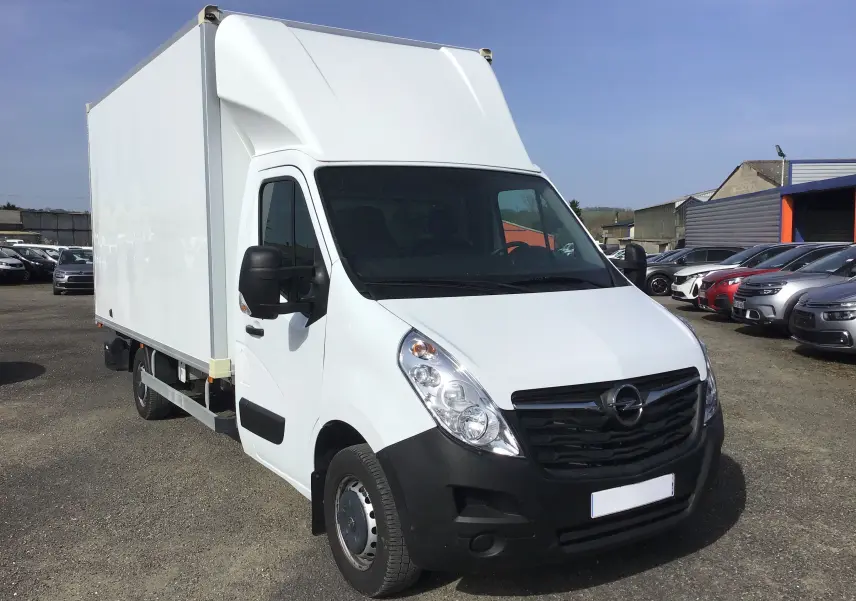 Vue 3/4 avant droite d'un Opel Movano blanc L3H1 avec caisse 20m3 et hayon, stationné en extérieur.