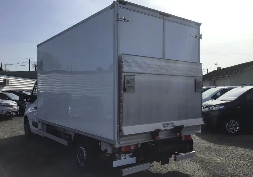 Vue 3/4 arrière droite d'un utilitaire blanc Opel Movano Chassis Cabine avec hayon élévateur et caisse fermée.