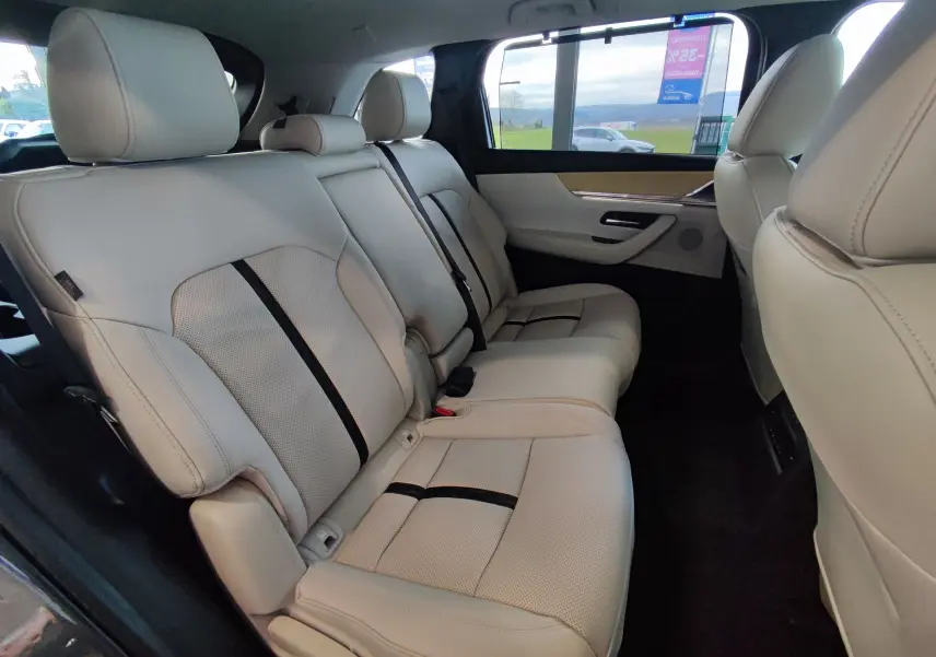 Vue intérieure côté droit des sièges arrière en cuir beige perforé du Mazda CX-80 2024 gris foncé Takumi Plus 7 places.