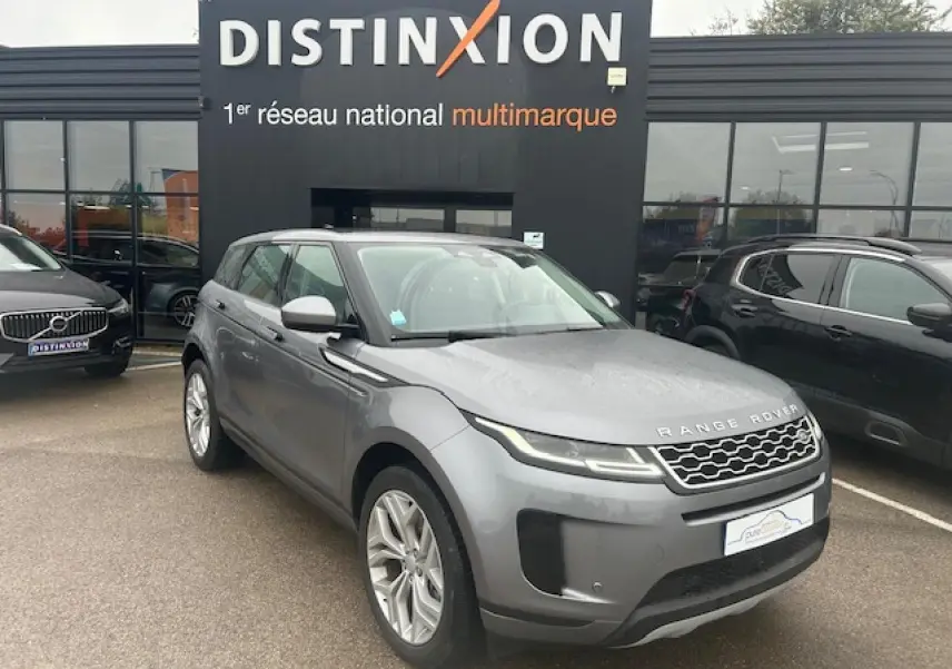 Range Rover Evoque gris foncé métallisé vu en 3/4 avant droit devant un showroom Distinxion.