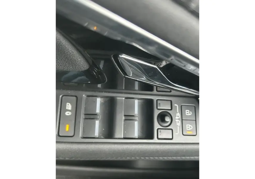 Gros plan sur les commandes des vitres et des rétroviseurs du Range Rover Evoque gris foncé intérieur cuir Ebony.