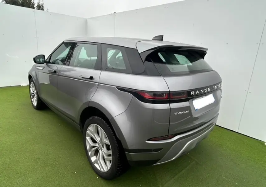 Vue 3/4 arrière droite d'un Range Rover Evoque gris foncé métallisé avec jantes 20 pouces et hayon électrique.