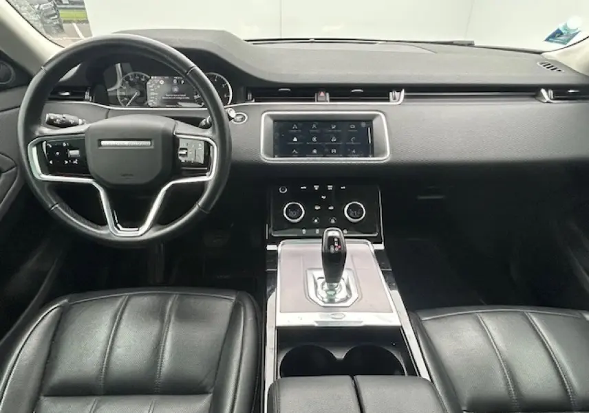 Intérieur noir du Range Rover Evoque 2022 vu de face, avec tableau de bord moderne et écran tactile central.