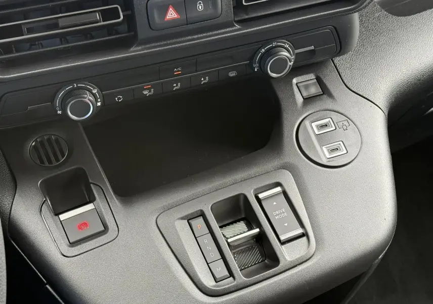 Vue rapprochée de la console centrale noire du Citroën Berlingo 2025 avec commandes de climatisation et boîte automatique.