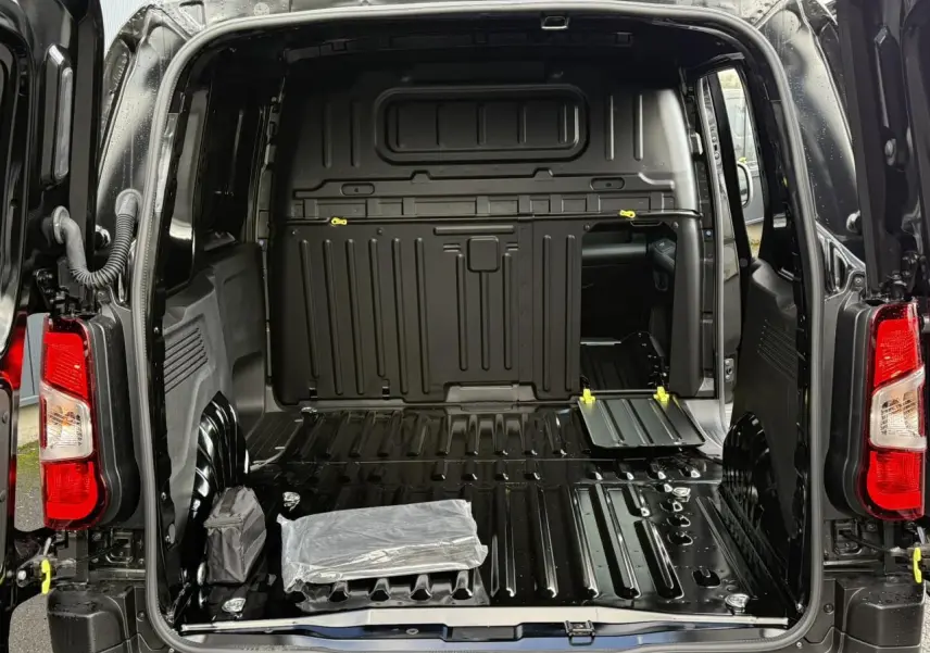 Vue arrière ouverte du Citroën Berlingo Van noir Perla, montrant l'espace de chargement tôlé et la cloison fixe.