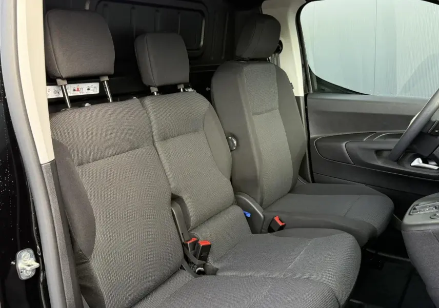 Intérieur du Citroën Berlingo Van 2025, vue latérale des sièges avant gris foncé avec banquette passager double.