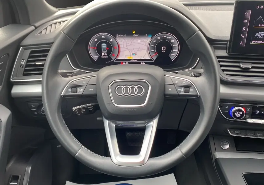 Vue rapprochée du volant cuir noir et du tableau de bord digital d’un Audi Q5 Business Edition S-Line 2022.