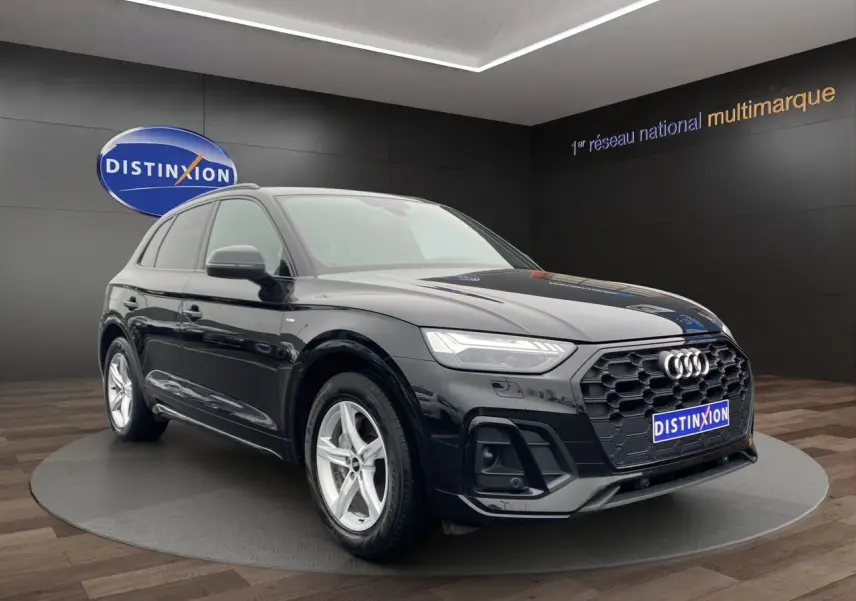 Audi Q5 Business Edition S-Line noir, vue 3/4 avant droit, avec calandre hexagonale et phares LED distinctifs.