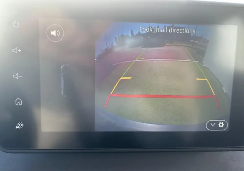 Écran tactile intérieur montrant la caméra de recul d'une Dacia Sandero III Stepway Beige Safari en marche arrière.