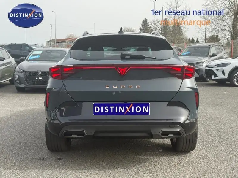 Vue arrière d'un CUPRA Formentor bleu foncé 2025 avec feux LED reliés et double sortie d'échappement intégrée.