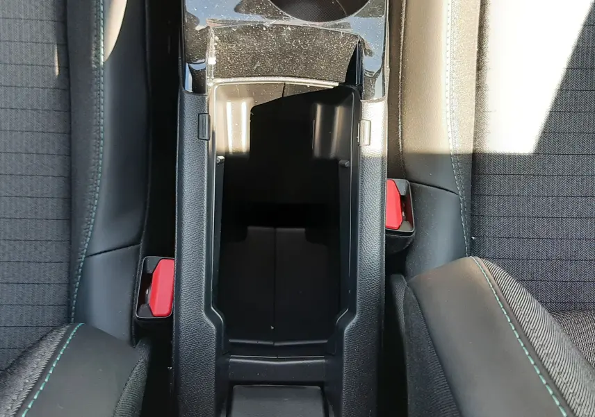 Vue plongeante sur la console centrale noire entre les sièges avant du Peugeot 2008 2023 finition Allure Pack.