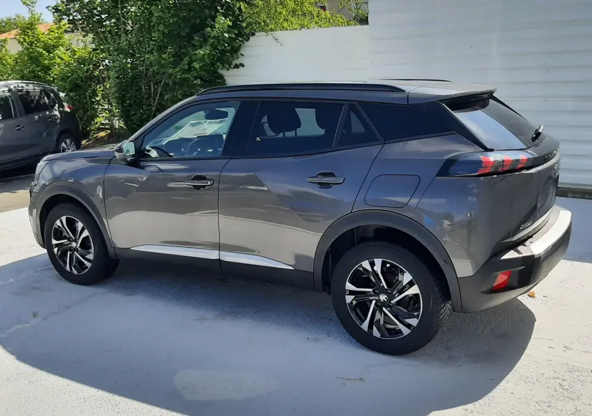 Peugeot 2008 gris platinium vue de profil côté gauche, avec toit noir et jantes alliage noires et argentées.