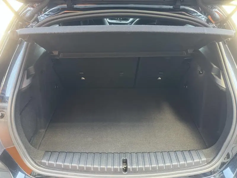 Coffre ouvert vu de l'arrière d'une BMW Série 1 noire, montrant un espace de chargement propre et spacieux.