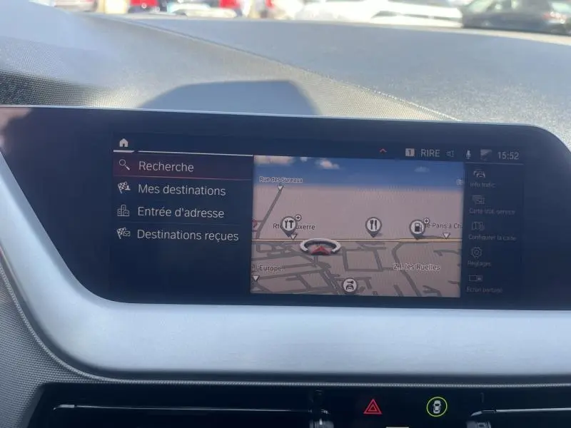 Écran tactile central affichant le système de navigation dans l'habitacle d'une BMW Série 1 noire de 2020.