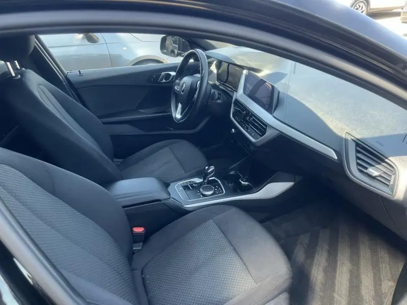 Intérieur de BMW Série 1 116d Lounge 2020 vu côté conducteur, sièges tissu anthracite et tableau de bord moderne.