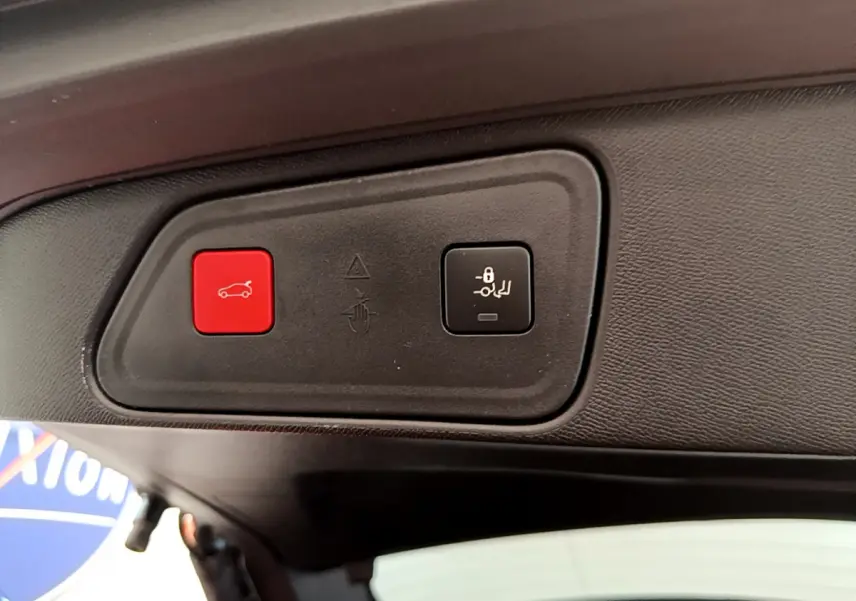 Gros plan sur les boutons d'ouverture et de verrouillage du coffre du Peugeot 3008 noir, vue intérieure arrière.
