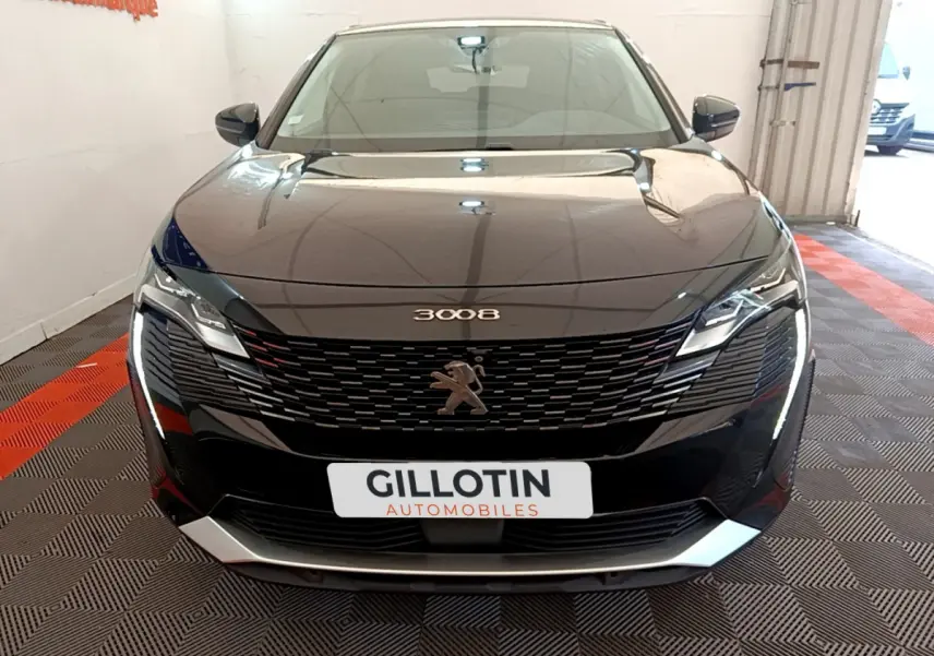 Vue avant d'un Peugeot 3008 noir 2022 avec calandre distinctive et phares LED dans un showroom.