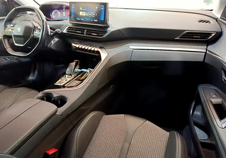 Intérieur du Peugeot 3008 noir, vue côté conducteur, tableau de bord moderne avec écran tactile et volant cuir multifonctions.