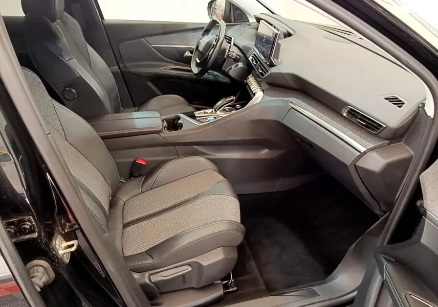 Intérieur avant droit du Peugeot 3008 noir 2022, sièges tissu et cuir, tableau de bord moderne avec écran tactile central.