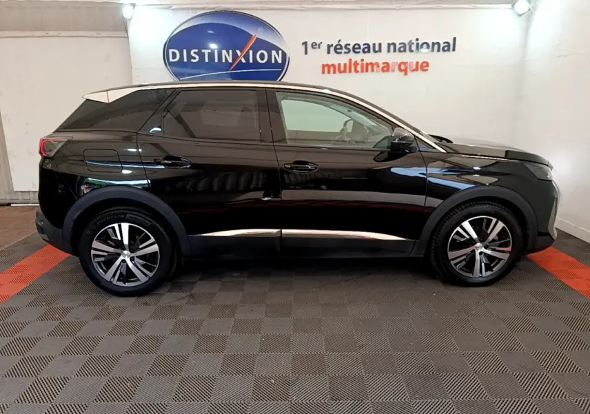 Profil côté gauche d'un Peugeot 3008 noir 2022 dans un showroom avec jantes alliage et vitres teintées.