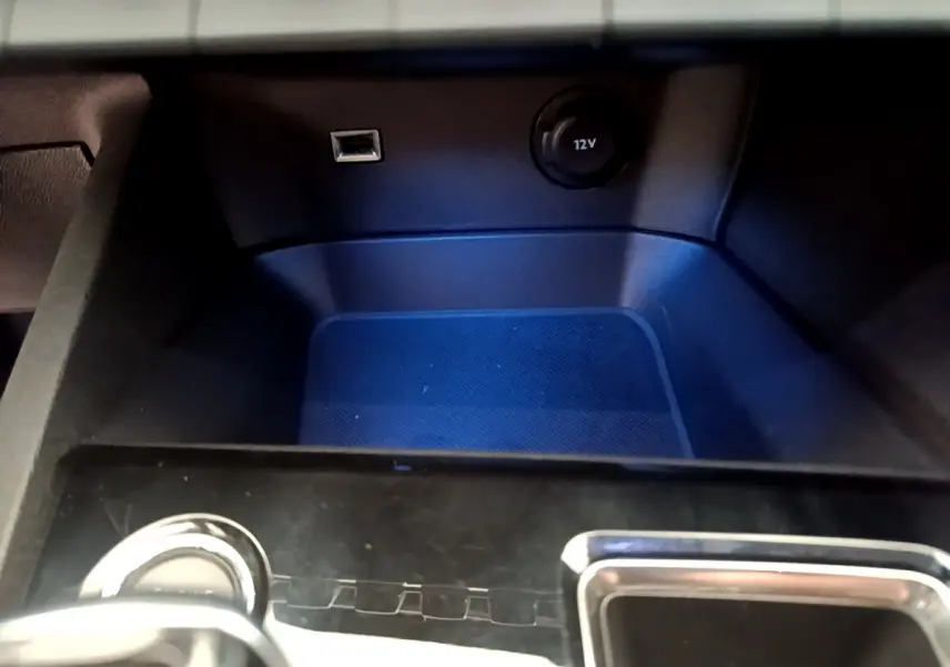 Gros plan sur la console centrale du Peugeot 3008 noir, montrant prise USB et prise 12V sous éclairage bleu.