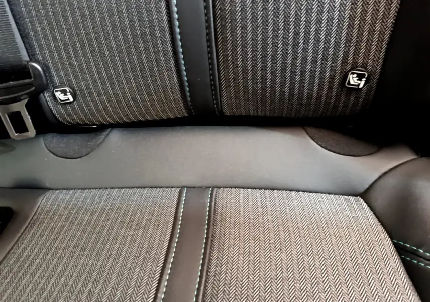 Gros plan sur la banquette arrière du Peugeot 3008 noir 2022, tissu à chevrons avec logos Isofix visibles.