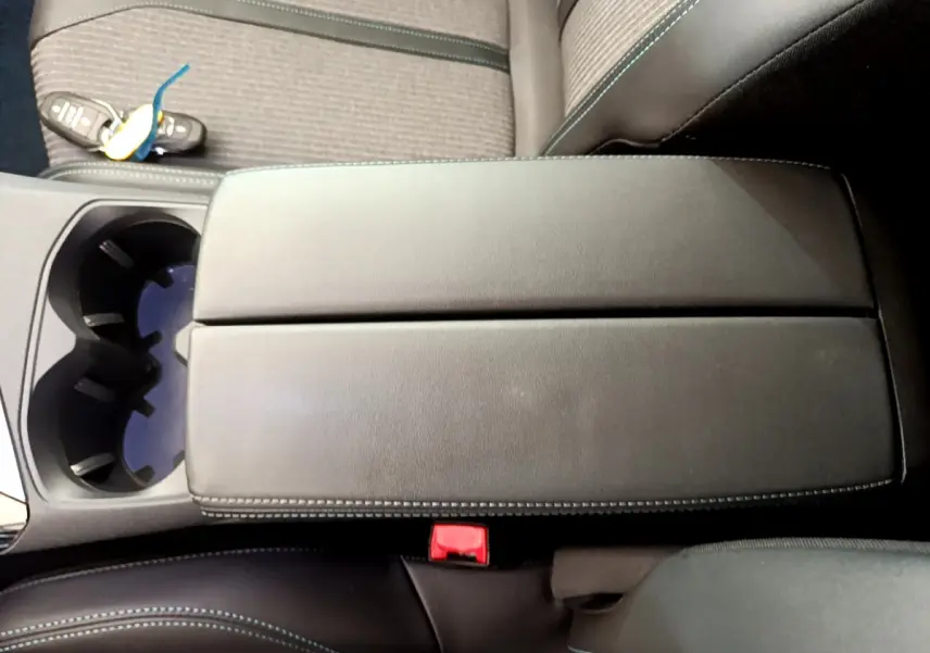 Vue rapprochée de l'accoudoir central noir et des sièges en tissu gris du Peugeot 3008 2022, version Allure Pack.