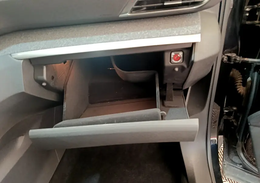 Vue intérieure côté passager du Peugeot 3008 noir 2022, boîte à gants ouverte avec éclairage intérieur visible