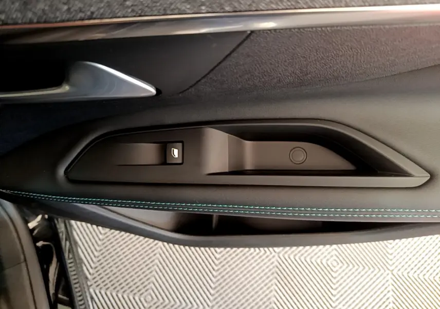 Gros plan sur la commande de lève-vitre côté gauche avec surpiqûres bleues sur la porte noire du Peugeot 3008 2022.
