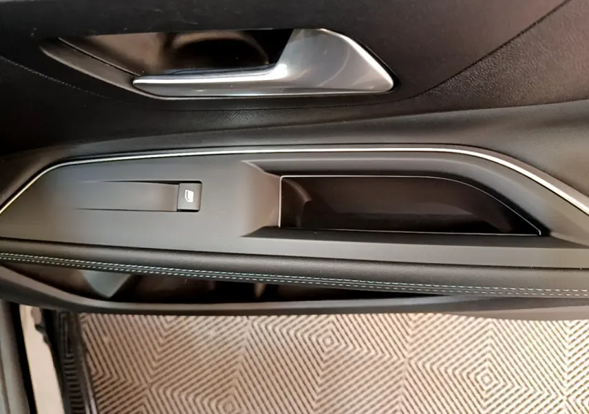 Poignée intérieure et commande de lève-vitre côté conducteur du Peugeot 3008 noir, finition Allure Pack 2022.