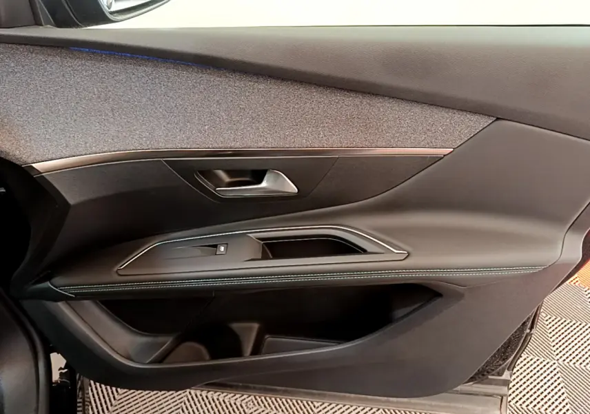 Vue rapprochée de la porte côté droit du Peugeot 3008 noir 2022, avec garniture cuir et insert décoratif argenté.