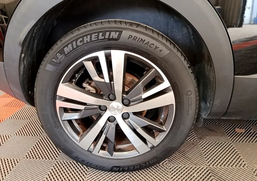 Gros plan sur la roue avant droite noire du Peugeot 3008 2022 avec jante alliage et pneu Michelin Primacy 4.
