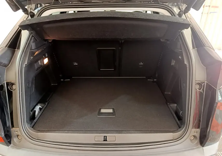 Coffre ouvert noir du Peugeot 3008 BlueHDi 130 S&S EAT8 Allure Pack vu de l'arrière, espace de chargement spacieux et propre.