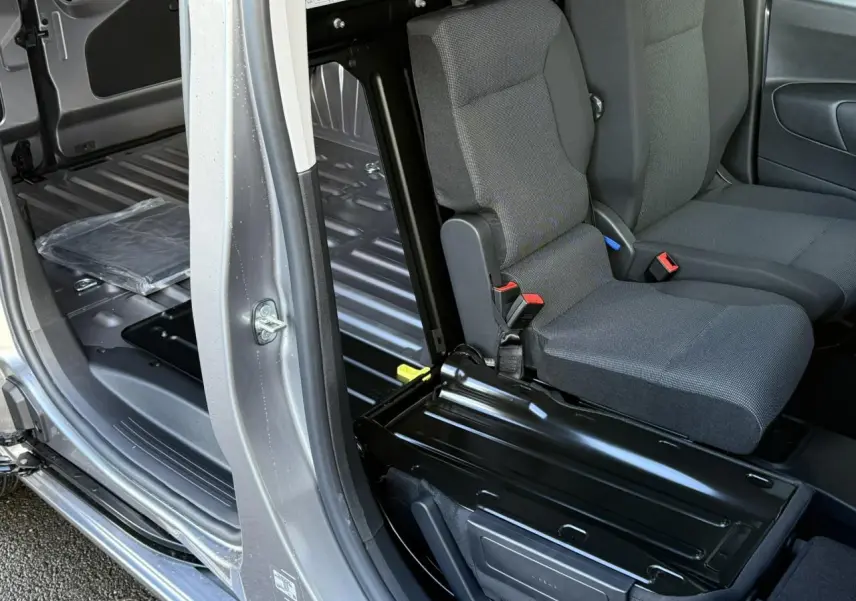 Vue intérieure côté droit du Citroën Berlingo gris Artense, montrant la banquette passager rabattue et l'espace de chargement tôlé.