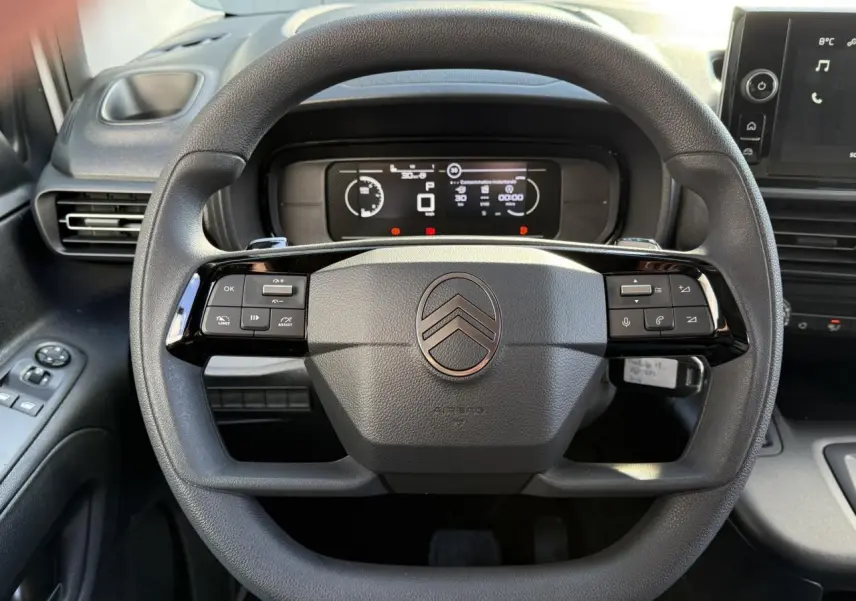 Vue rapprochée du volant multifonctions Citroën Berlingo 2025 avec tableau de bord numérique et commandes intégrées.