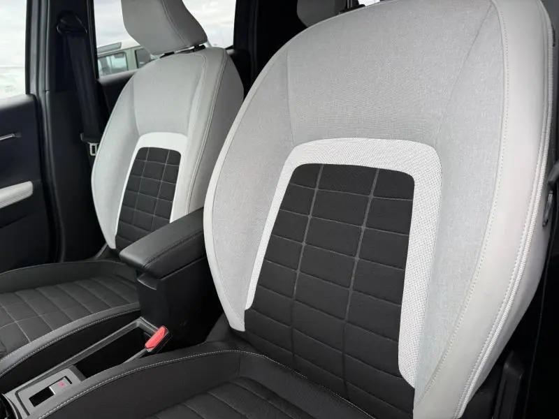 Gros plan sur les sièges avant bicolores gris clair et noir de la Citroën C3 électrique 2025, finition MAX.