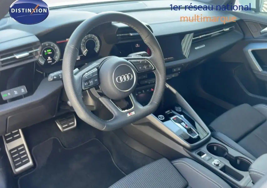 Vue intérieure de l'Audi A3 Sportback 2025, tableau de bord et volant multifonction en cuir noir avec finitions modernes.