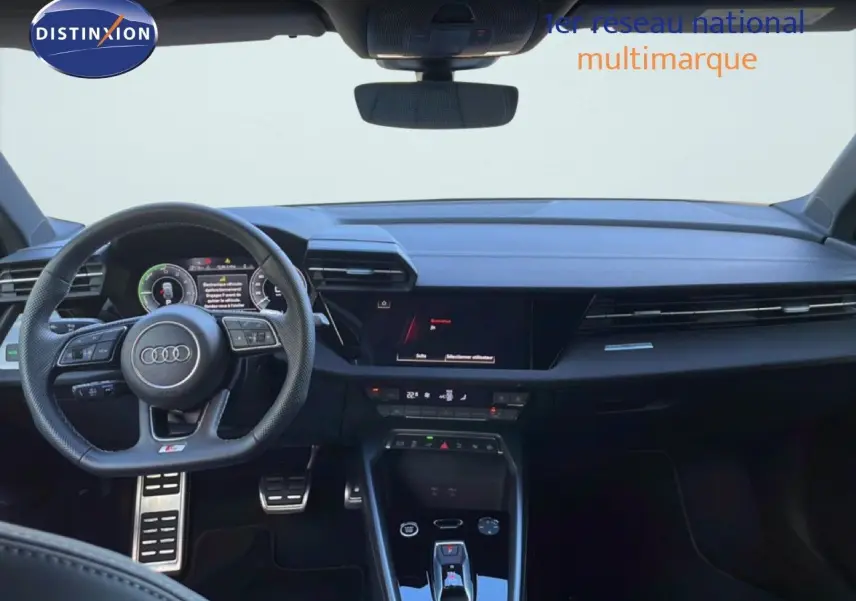 Vue intérieure avant de l'Audi A3 Sportback 40 TFSIe blanc Ibis, tableau de bord et volant multifonction S-Line visibles.