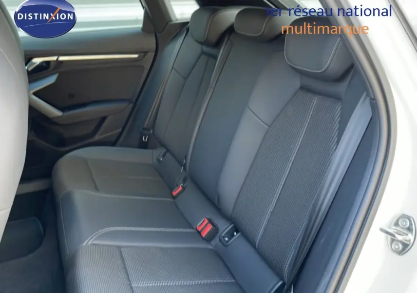 Vue intérieure côté droit des sièges arrière en tissu et cuir gris noir de l'Audi A3 Sportback blanc Ibis 2025.