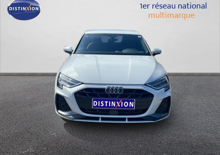 Vue avant d'une Audi A3 Sportback blanche Ibis 2025 avec calandre noire et logo Audi distinctif.