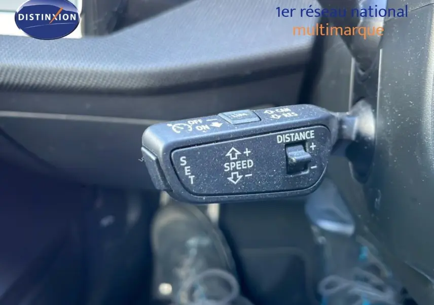 Gros plan sur la commande de régulateur de vitesse adaptatif dans l'habitacle de l'Audi A3 Sportback blanc Ibis 2025.