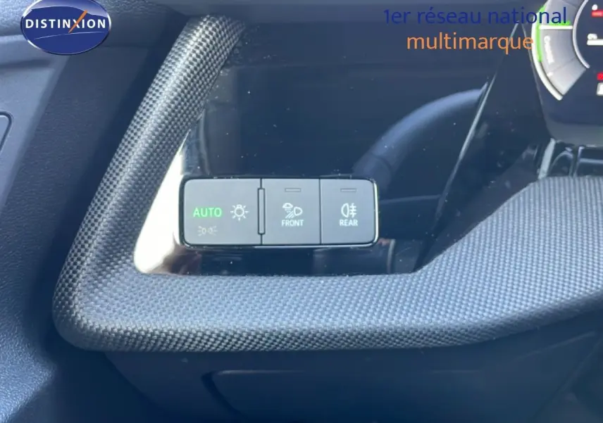 Détail du tableau de bord de l'Audi A3 Sportback 2025 blanc Ibis, avec commandes d'éclairage et finition carbone.