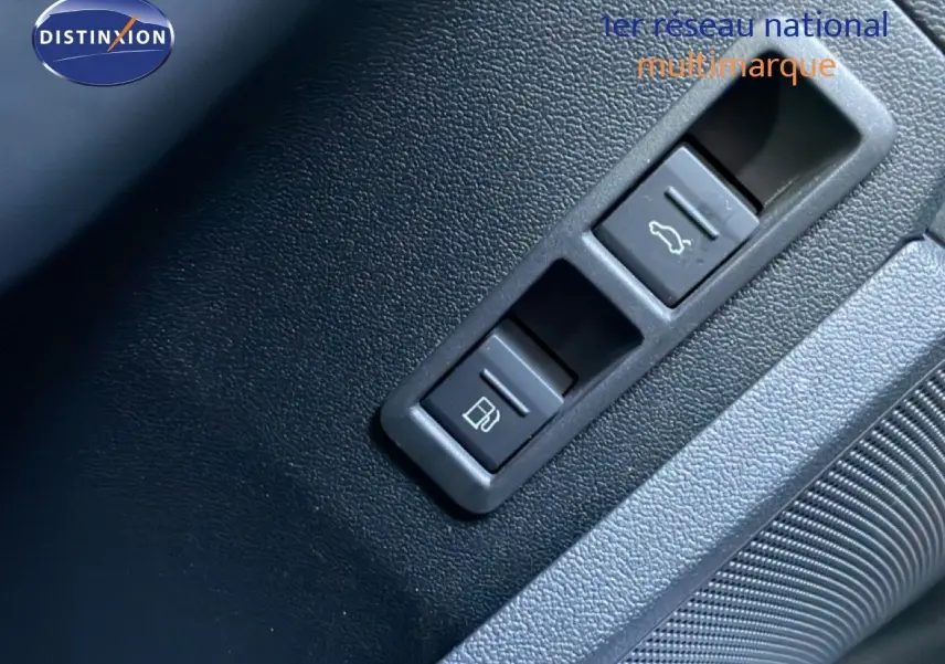 Gros plan sur les commandes d’ouverture du coffre et de la trappe à carburant dans l’Audi A3 Sportback blanc Ibis 2025.