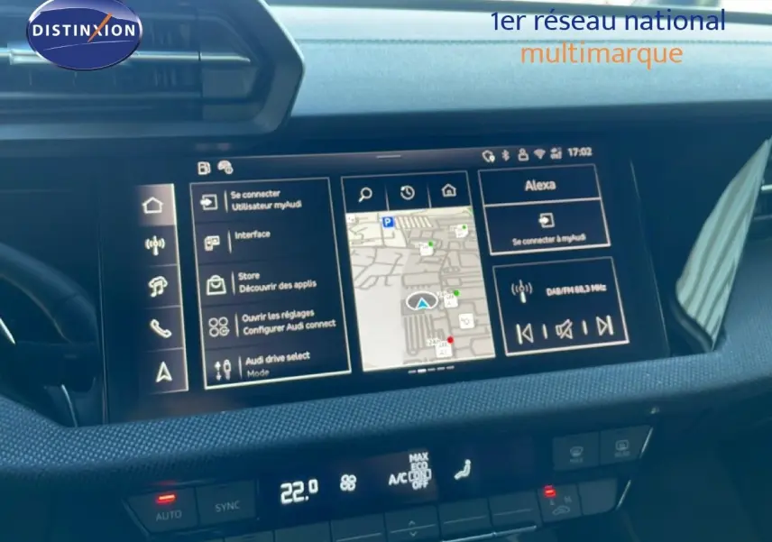 Vue intérieure du tableau de bord de l'Audi A3 Sportback blanc Ibis 2025 avec écran tactile et commandes climatisation.