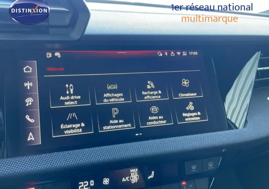 Vue rapprochée de l'écran tactile central de l'Audi A3 Sportback 2025, affichant les options de véhicule et climatisation.