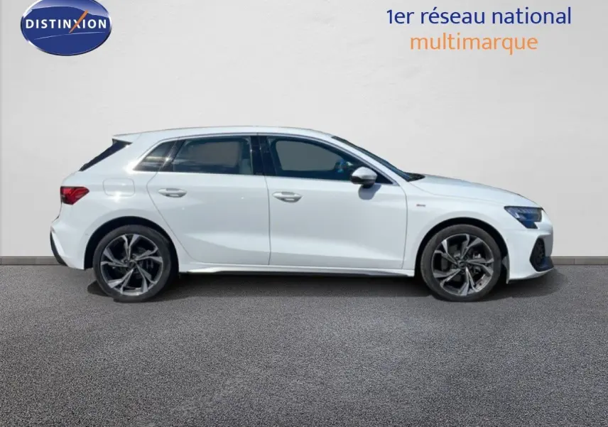 Profil droit d'une Audi A3 Sportback blanche Ibis 2025 avec jantes alliage et finition S-Line visible.
