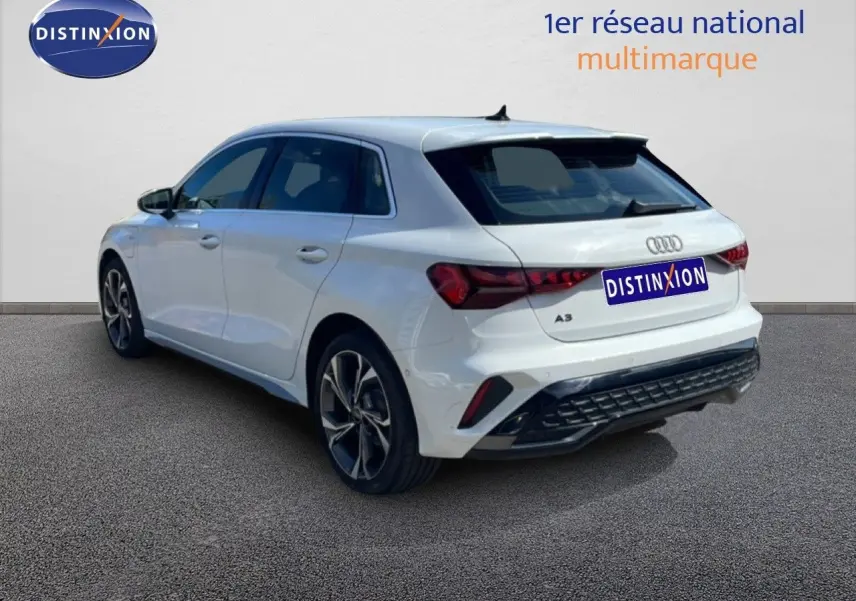 Audi A3 Sportback blanc Ibis en 3/4 arrière droit, mettant en valeur ses feux arrière LED et ses jantes alliage.