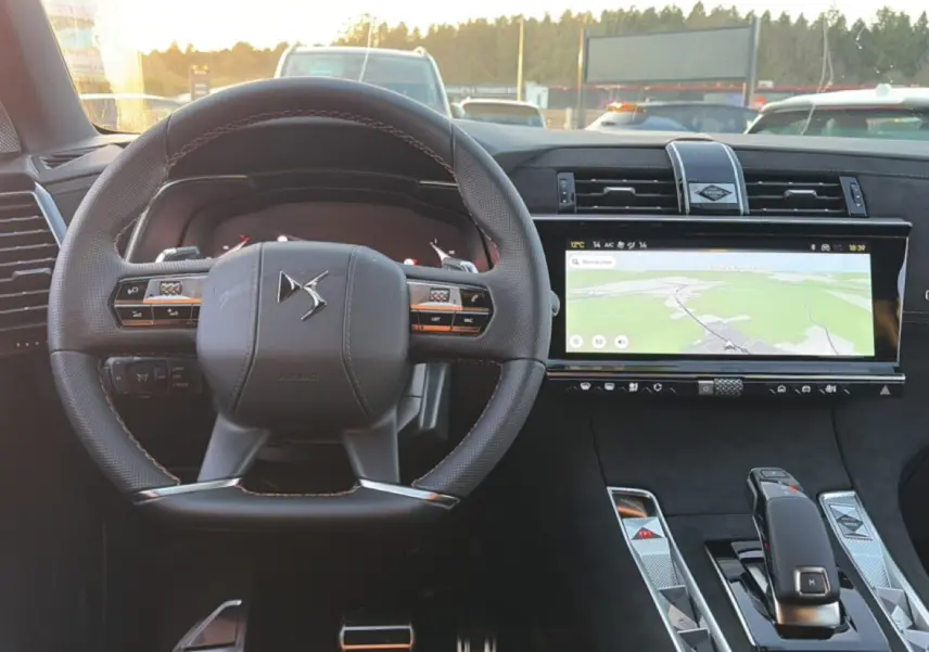 Vue intérieure avant du DS7 noir 2026, volant cuir avec commandes intégrées et grand écran tactile GPS.