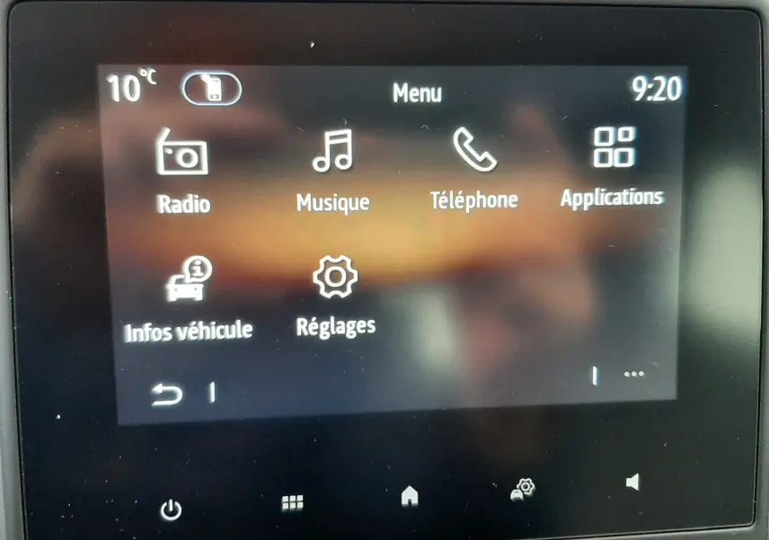 Écran tactile central de la Renault Clio V gris schiste, affichant le menu principal avec options radio, musique et téléphone.